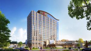 Digital rendering of a modern hotel building during the day, featuring a tall structure with large windows, a prominent logo at the top, and people and cars around the entrance.